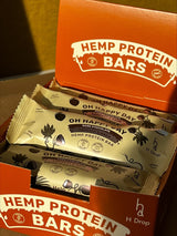 Oh Happy Day – kaņepju proteīna batoniņš ar kokosriekstu un maca, tumšajā šokolādē (12 gab. kastīte)